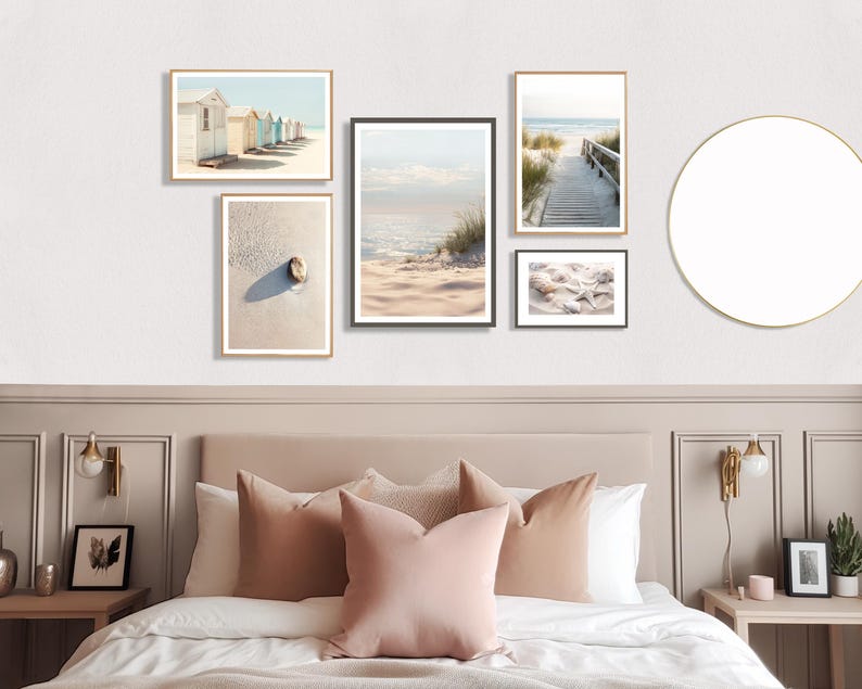 May include: A collection of framed beach-themed art prints. The prints feature coastal scenes, including beach huts, a sandy beach with a shell, a wooden walkway to the sea, and seashells. The frames are in gold and black, creating a cohesive gallery wall.