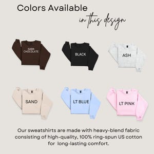 May include: A display of sweatshirts in various colors: dark chocolate, black, ash, sand, light blue, and light pink. The text "Colors Available in this design" is at the top. The bottom text states the sweatshirts are made with heavy-blend fabric.