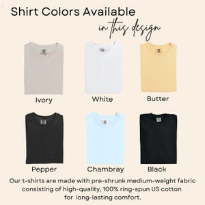 May include: Image showcasing six t-shirt color options: Ivory, White, Butter, Pepper, Chambray, and Black. The text "Shirt Colors Available in this design" is displayed at the top. The description states the shirts are made with pre-shrunk, medium-weight, 100% ring-spun US cotton.