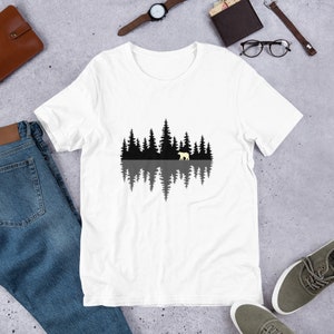 May include: White t-shirt with a black silhouette of a forest reflected in water with a white bear walking in the forest.