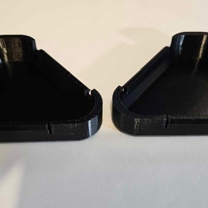 May include: Two black triangular plastic containers with a smooth, glossy finish. The containers are open and appear to be part of a set.