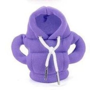 May include: A small, lavender-colored hoodie with a hood and sleeves. The hoodie has a white drawstring with silver-colored aglets. The fabric appears to be a soft, textured material.