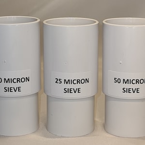 May include: Three white plastic sieves with labels indicating their micron size: 10 micron sieve, 25 micron sieve, and 50 micron sieve.