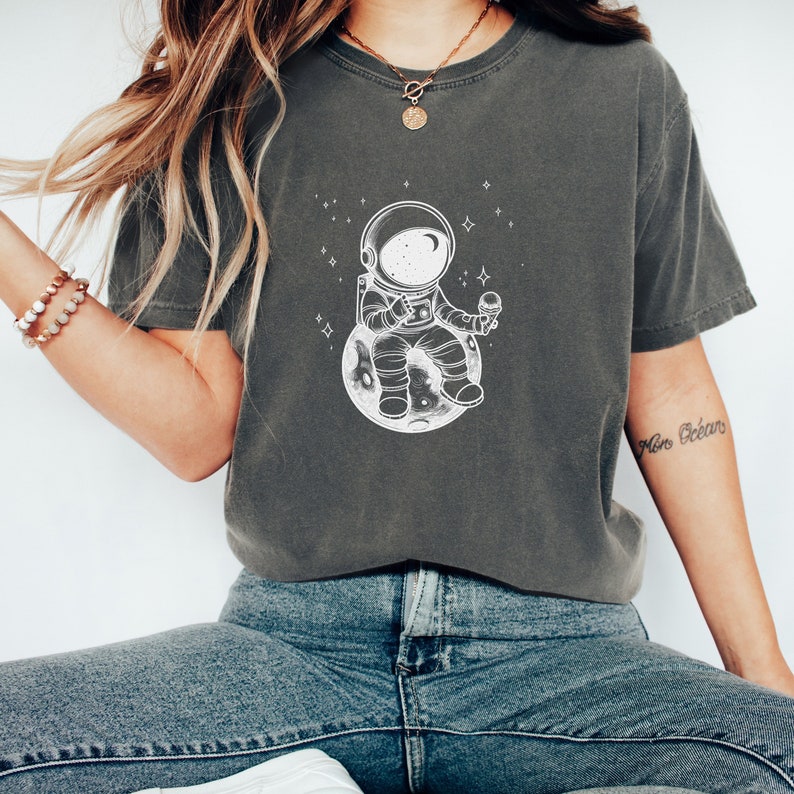 Celestial Gift Tee With A Little Spaceman Sitting On A Tiny Planet Eating Ice Cream. Stargazing And Ice Cream Lover Shirt.