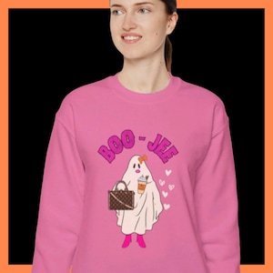 May include: Pink sweatshirt with the text "BOO - JEF" in pink bubble letters. The graphic shows a ghost wearing pink boots, holding a purse and a coffee cup. White hearts are on the right side of the ghost.