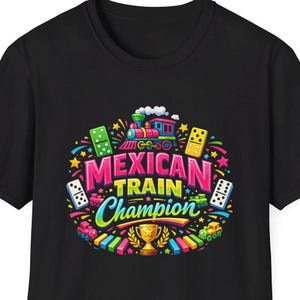 May include: Black t-shirt featuring a colorful graphic design. The design includes a train, dominoes, stars, and the words "Mexican Train Champion" in a circular arrangement. A gold trophy is at the bottom of the design.
