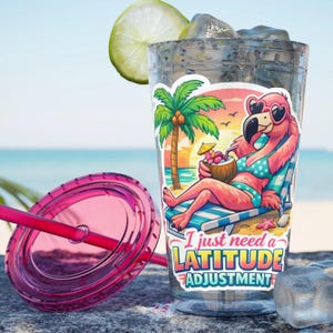Pode incluir: Um copo de plástico transparente com gelo e uma fatia de limão. Um adesivo no copo apresenta um flamingo de desenho animado com óculos de sol, relaxando em uma cadeira de praia com uma bebida de coco. O texto no adesivo diz: "I just need a LATITUDE ADJUSTMENT."