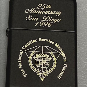 Pu&ograve; includere: Accendino in metallo nero con la scritta "25th Anniversary San Diego 1996". L'accendino presenta anche il logo del National Cadillac Service Managers' Council in oro.