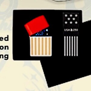 May include: Limited Edition Packaging showing a red-topped lighter with a gold and white striped design, open to reveal blue contents. A black card displays a US flag design and the text "USA b 250". A red "N" is visible.