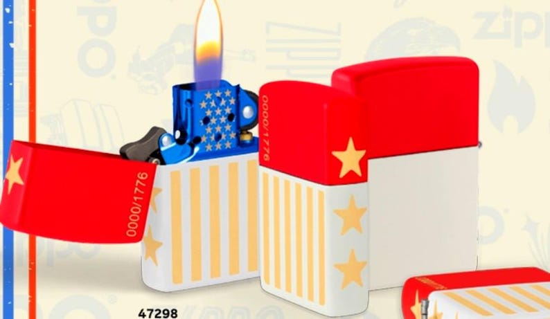 May include: A patriotic-themed lighter with a blue top decorated with white stars and a red lid featuring a gold star. The body is white with yellow stripes and gold stars. The lighter is lit, showing a flame.