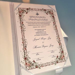 K&ouml;nnte beinhalten: Eine wei&szlig;e Keramik-Tasse mit schwarzem Henkel und dem Text "But First, Coffee" in schwarzer, handschriftlicher Schrift. Die Tasse steht auf einer wei&szlig;en Oberfl&auml;che.
