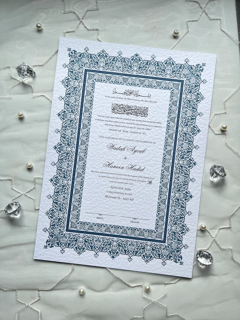 Op de afbeelding: Een formeel huwelijkscertificaat met sierlijke teal randen en tekst. Het document bevat Arabische schrifttekens en Engelse tekst, met namen en een datum. Decoratieve elementen zijn bloemmotieven en een delicaat ontwerp.
