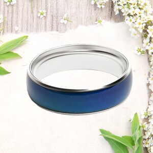 May include: A silver mood ring with a blue band that changes color based on your mood.
