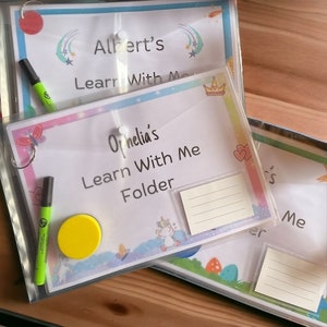 May include: Three clear plastic folders with colourful designs and the text "Learn With Me" on each. The top folder has the name "Albert's" on it, the middle folder has the name "Ophelia's" on it, and the bottom folder has the name "_s" on it. Each folder has a clear pocket on the front.