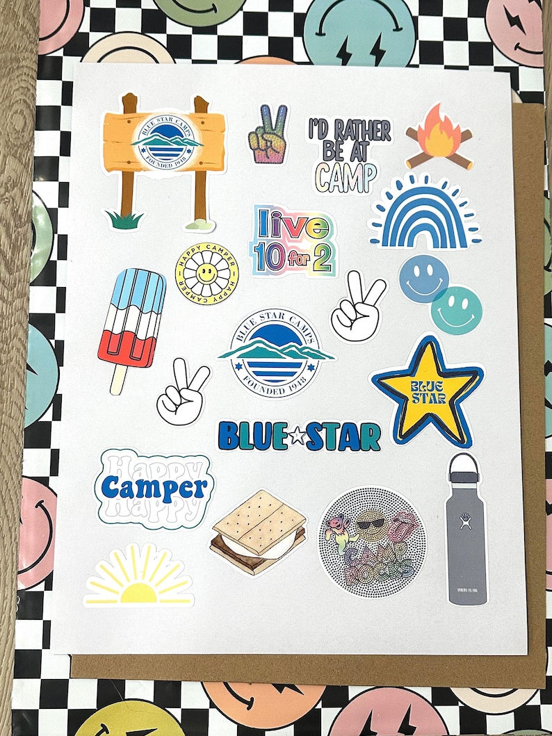 May include: A collection of colorful stickers featuring camping-themed designs, including a peace sign, a campfire, a rainbow, a smiley face, a popsicle, a s'more, a water bottle, and a sun. The stickers also feature text that says "Blue Star Camps", "Happy Camper", "Live 10 for 2", and "I'd Rather Be at Camp".