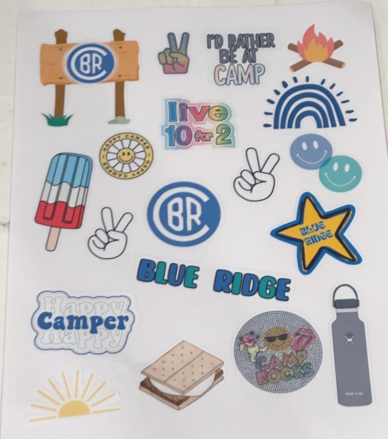 May include: A sheet of colorful stickers with a camp theme. The stickers feature a variety of designs, including a campfire, a rainbow, a peace sign, a popsicle, a s'more, a water bottle, and a star with the words "Blue Ridge" on it. The stickers also feature the letters "BR" in a circle, the words "Happy Camper", and the words "I'd rather be at camp".