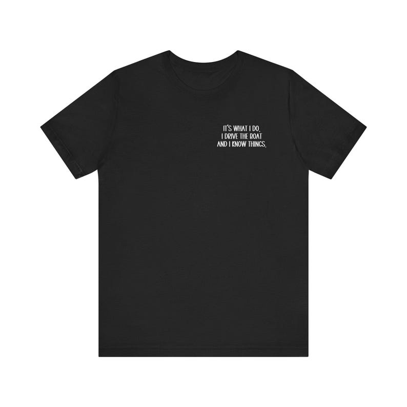 May include: Black t-shirt with white text that reads "It's what I do. I drive the boat and I know things."