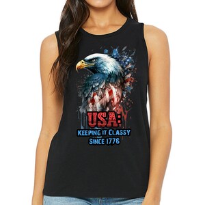 Könnte beinhalten: Schwarzes ärmelloses Shirt mit einer Grafik eines amerikanischen Weißkopfseeadlers mit rot-weiß-blauen Federn. Der Adler ist von einem rot-weiß-blauen Spritzmuster umgeben. Der Text "USA: KEEPING IT CLASSY SINCE 1776" ist unter dem Adler gedruckt.