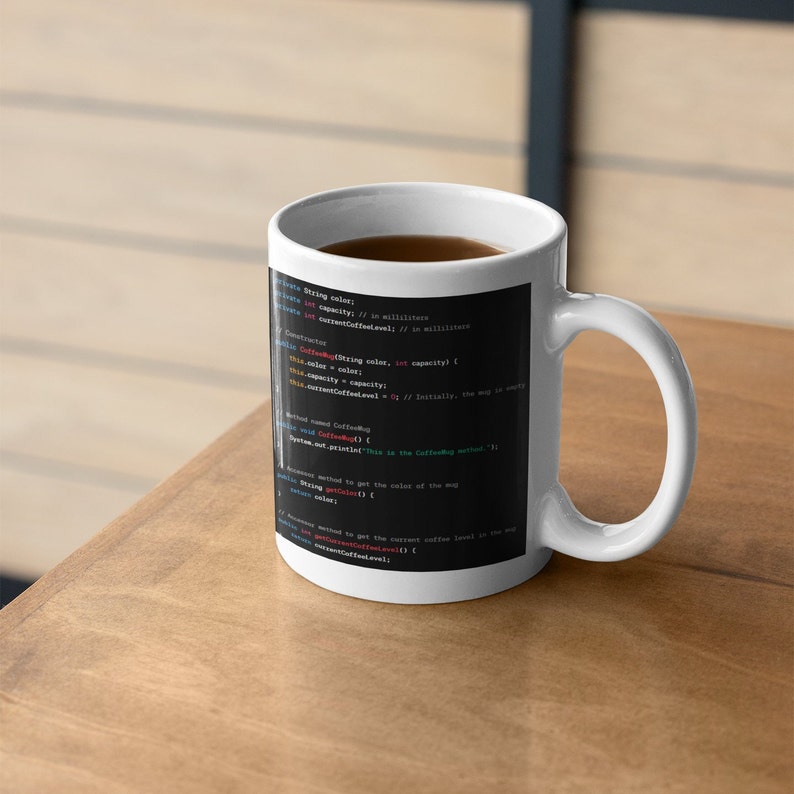 May include: White ceramic mug with a black background featuring code for a "Coffee" class. The code includes variables for "capacity", "color", and "currentCoffeeLevel".