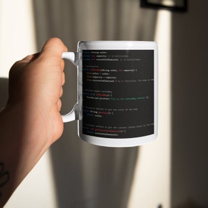 May include: White coffee mug with black text that reads: "private String color; private int capacity; // in milliliters private int currentCoffeeLevel; // in milliliters // Constructor public CoffeeMug(String color, int capacity) { this.color = color; this.capacity = capacity; this.currentCoffeeLevel = 0; // Initially, the mug is empty // Method named CoffeeMug public void CoffeeMug() { System.out.println("This is the CoffeeMug method."); } // Accessor method to get the color of the mug public String getColor() { return color; } // Accessor method to get the current coffee level in the mug public int getCurrentCoffeeLevel() { return currentCoffeeLevel; }"