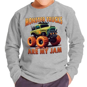Pu&ograve; includere: Una felpa grigia a maniche lunghe con un'immagine di un camion mostro di cartoni animati e il testo "Monster Trucks Are My Jam".