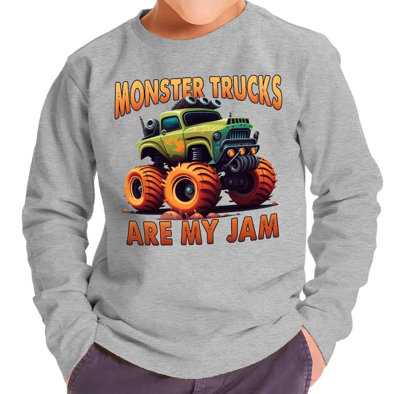 Pu&ograve; includere: Una felpa grigia a maniche lunghe con un'immagine di un camion mostro di cartoni animati e il testo "Monster Trucks Are My Jam".