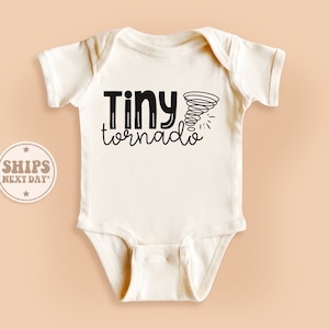 May include: White baby onesie with black text that reads "Tiny tornado" and a black tornado graphic.