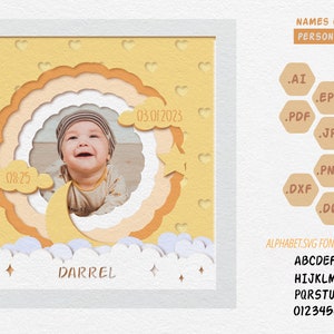 May include: A personalized baby photo frame with a smiling baby's photo, the name "Darrel", and the date 03/01/2023. The frame has a yellow and orange color scheme with a moon, stars, and cloud design. The text "NAMES CAN BE PERSONALIZED" is also included.