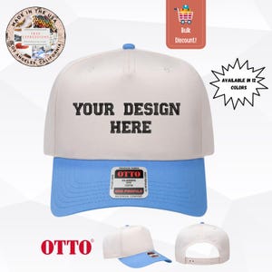 Könnte beinhalten: Eine zweifarbige Baseballkappe mit cremefarbener Krone und hellblauem Schirm. Auf der Vorderseite befindet sich der schwarz gestickte Text "YOUR DESIGN HERE". Ein Aufkleber der Marke OTTO ist auf dem Schirm zentriert und ein Verschluss ist sichtbar.