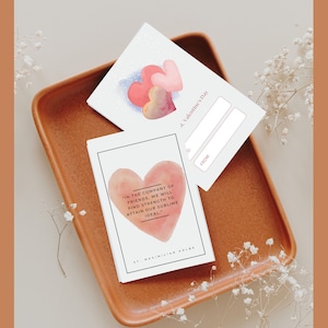 May include: Two Valentine's Day cards with watercolor hearts. One card has a quote by St. Maximilian Kolbe: "In the company of friends, we will find strength to attain our sublime ideal."