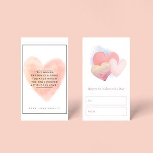 May include: A printable Valentine's Day card with a watercolor illustration of three pink hearts. The card has space to write "To:" and "From:" and includes the quote "The human person is a good towards which the only proper attitude is love." - Pope John Paul II.