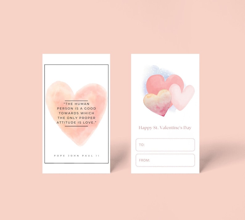 May include: A printable Valentine's Day card with a watercolor illustration of three pink hearts. The card has space to write "To:" and "From:" and includes the quote "The human person is a good towards which the only proper attitude is love." - Pope John Paul II.
