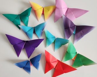 May include: A collection of ten origami butterflies in various colors, including purple, blue, green, red, yellow, and pink. The butterflies are folded from paper and have a delicate, intricate design.