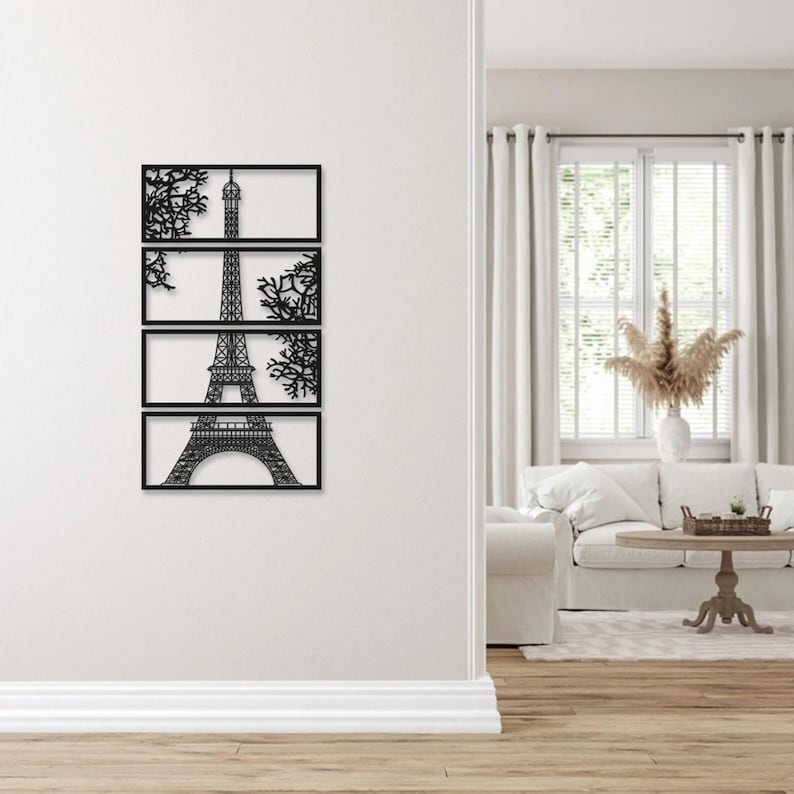 May include: Black metal wall art featuring a silhouette of the Eiffel Tower with tree branches on either side. The art is divided into four rectangular panels.