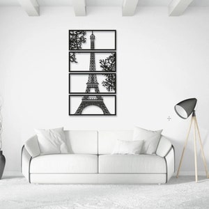 May include: Black metal wall art featuring a silhouette of the Eiffel Tower with tree branches on either side. The art is divided into five rectangular sections.