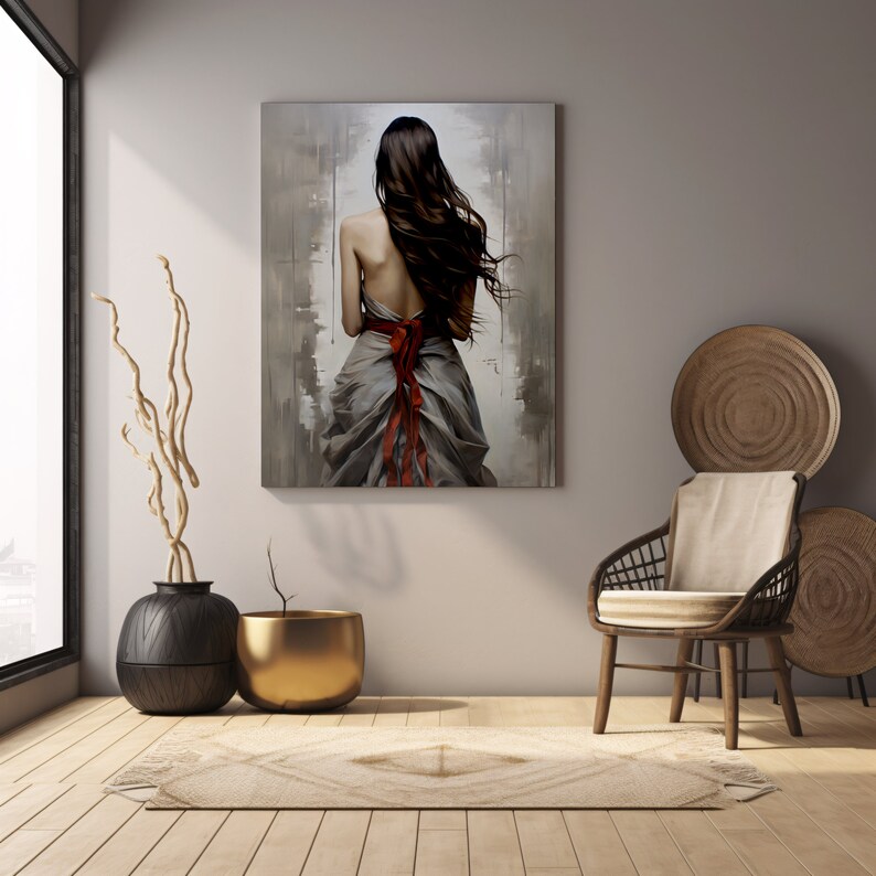 May include: A painting of a woman in a flowing grey dress with a red ribbon tied around her waist. The woman is standing with her back to the viewer, her long dark hair flowing in the wind. The background is a blurred abstract design in shades of grey and brown.