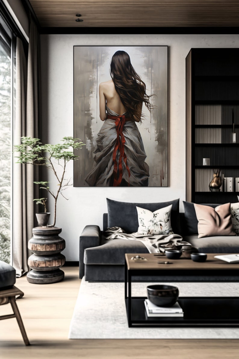 May include: A painting of a woman with long brown hair wearing a flowing gray dress with a red ribbon tied around her waist. The painting is set against a muted background with brushstrokes visible.
