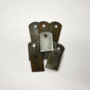 May include: A collection of metal tabs with a rectangular shape and a single circular hole near the top. The tabs have a mix of silver and rust-colored surfaces, suggesting they are made of steel and have undergone some oxidation.