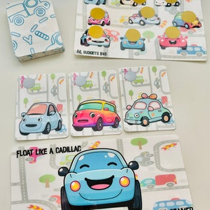 May include: A collection of colorful car-themed cards and a stack of matching patterned cards. The cards feature cartoon cars with smiling faces and the text "FLOAT LIKE A CADILLAC" and "STING LIKE A BEAMER". The cards are designed with a road and tree background.