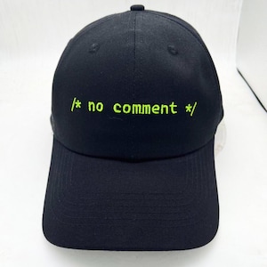 May include: Black baseball cap with a green embroidered design that says "/* no comment */"