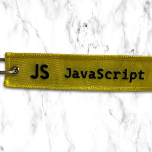 K&ouml;nnte beinhalten: Gelber Stoffschl&uuml;sselanh&auml;nger mit schwarzen N&auml;hten und dem aufgestickten Text "JS JavaScript".