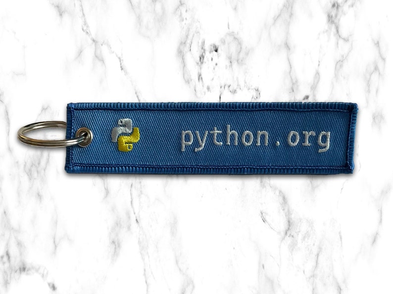 K&ouml;nnte beinhalten: Ein blauer Schl&uuml;sselanh&auml;nger mit einem gelben und wei&szlig;en Python-Logo und dem Text "python.org" darauf gestickt.