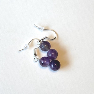 May include: Amethyst gemstone earrings with three round beads on silver hooks.