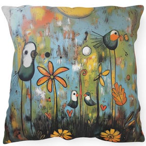 May include: A colorful throw pillow with a whimsical design featuring stylized birds, flowers, and a sun. The background is a blue and green abstract pattern.