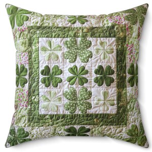 May include: A green and white quilted pillow with a shamrock design. The pillow is square and has a white background with green shamrocks of varying sizes.