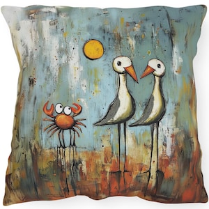 May include: Square decorative pillow featuring an artistic illustration of two stylized birds with long legs, a crab, and a yellow sun against a blue and orange background. The artwork has a whimsical, painted style.