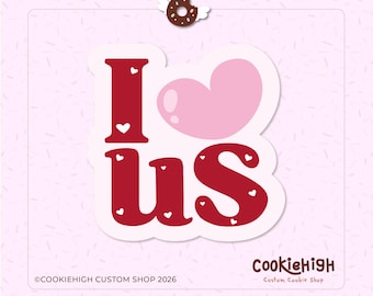 Op de afbeelding: Een sticker met de woorden "I us" in het rood, met een roze hart dat het woord "love" vervangt. Kleine witte hartjes versieren de letters. Een donut met vleugels en een halo zit boven de sticker. De achtergrond is lichtroze.