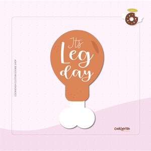 May include: A cartoon chicken leg graphic with the text "It's Leg day" in white script. The background is a light pink with small white dots. A donut with wings and a halo is in the upper right corner.