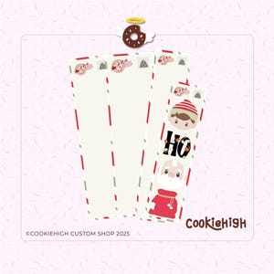 May include: Christmas-themed bookmarks with a festive design. The bookmarks feature an elf, Santa Claus, and the word "HO" in a playful font. The design includes red and green accents, and a donut with wings.
