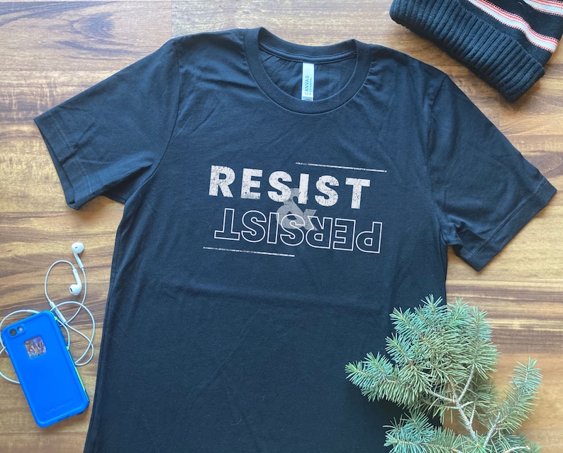 May include: Black t-shirt with white text that reads "Resist & Persist".